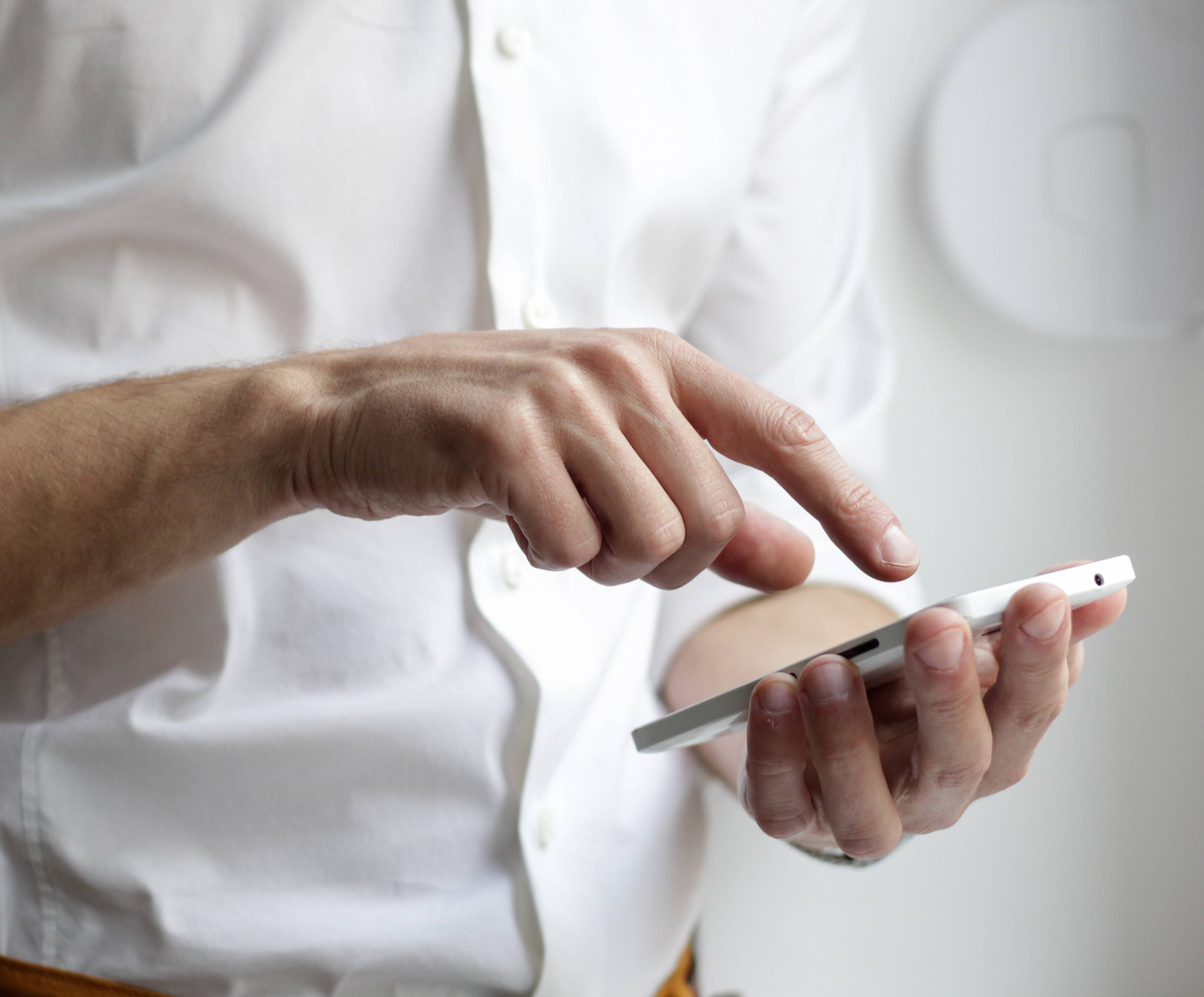 KI generiert: Das Bild zeigt eine Person, die auf einem Smartphone tippt. Der Fokus liegt auf den Händen und dem Gerät, während der Hintergrund unscharf ist.