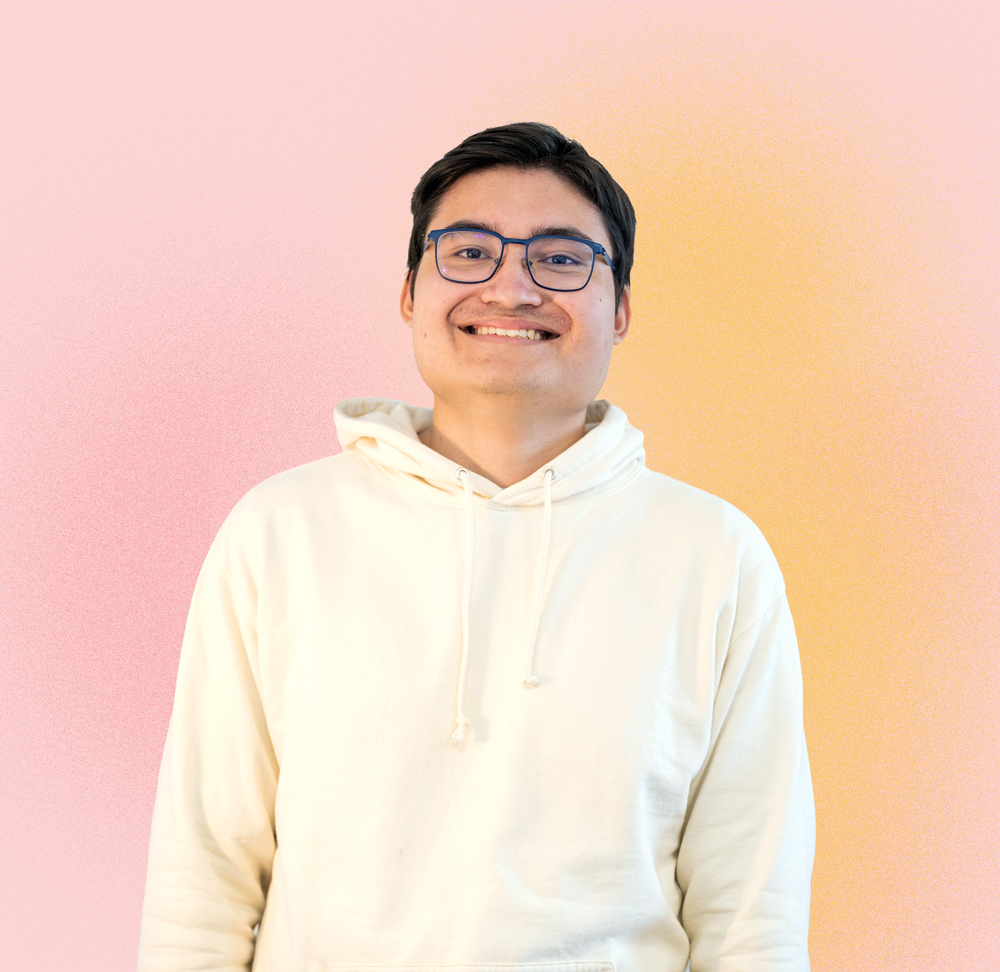 KI generiert: Das Bild zeigt einen lächelnden Mann mit Brille, der eine weiße Kapuzenjacke trägt und vor einem Hintergrund mit einem sanften Farbverlauf von Rosa zu Orange steht.