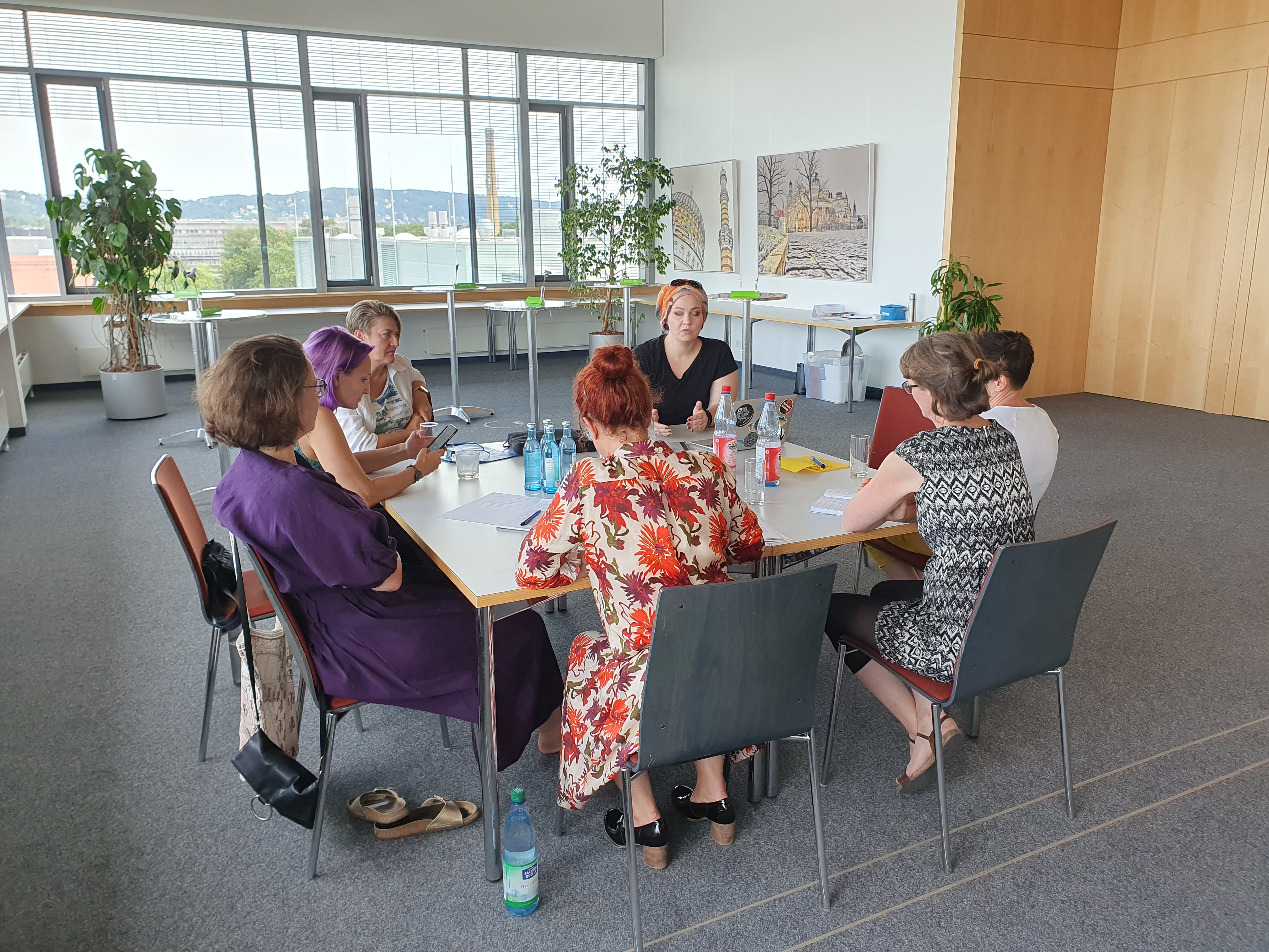 Acht Teilnehmende sitzen in einer Diskussionsrunde um einen Tisch im BioInnovationszentrum