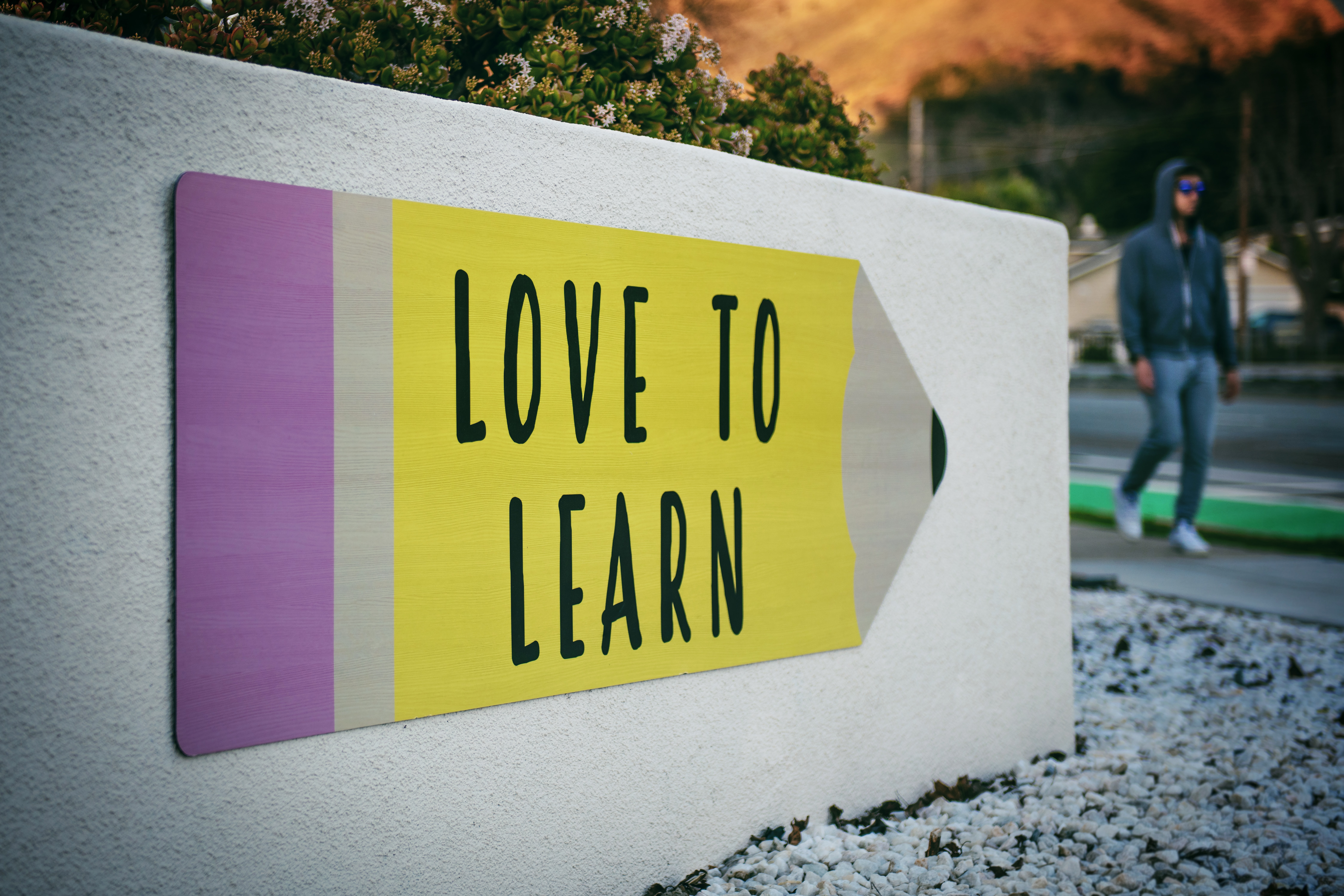 Schild mit Aufschrift "Love to Learn" in Form eines Bleistifts