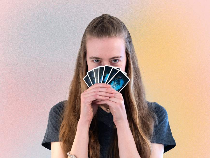 KI generiert: Das Bild zeigt eine lächelnde Frau mit langen, braunen Haaren, die vor einem hellen, pastellfarbenen Hintergrund steht.