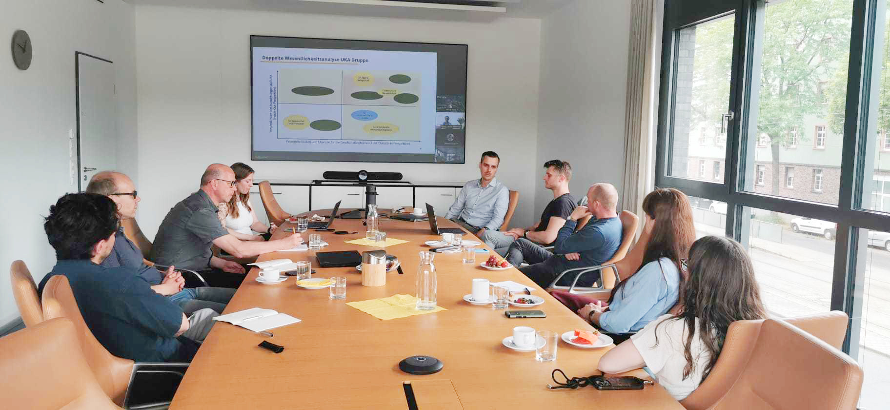 KI generiert: Eine Gruppe von Menschen sitzt in einem Konferenzraum und hält eine Präsentation ab.